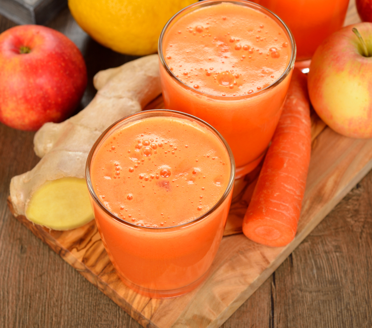 Fresh apple and carrot juice on brown background